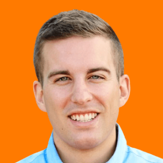 A headshot of Andrew Harder smiling, wearing a light blue shirt against an orange background.