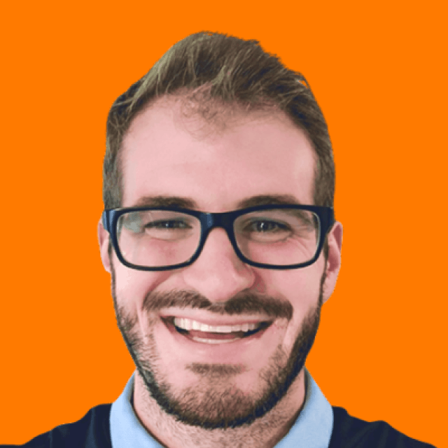Tim Davidson is smiling, wearing glasses and a beard against an orange background, exuding a friendly and approachable vibe.